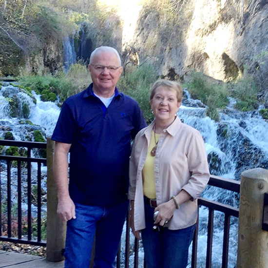 A couple posed in front of a waterfall