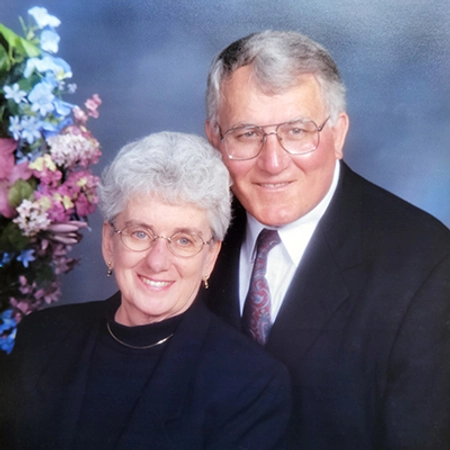Frank and his late wife, Jean, smiling in a professional photo.