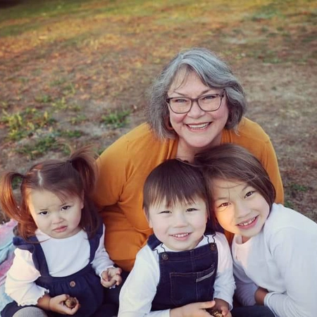 laurie stiegelmeier smiles outside with her some of her grandkids
