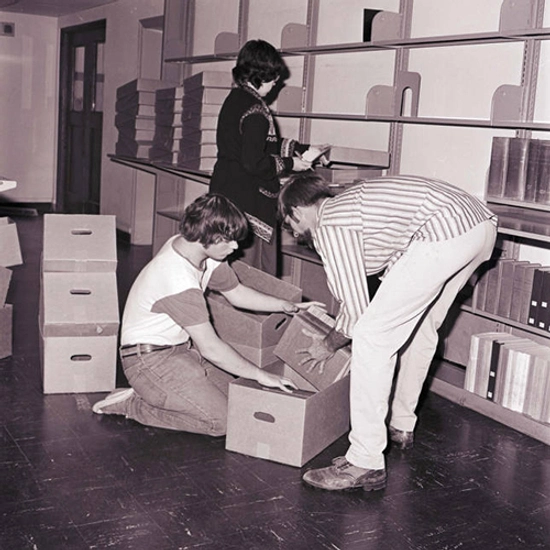 People packing up books into boxes.