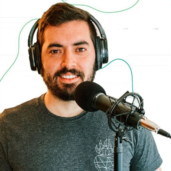 Headshot of Luis with headphones on a microphone