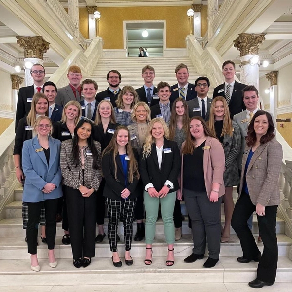 maddie and a group of other sdsu students stand on the stairs of the south dakota capitol