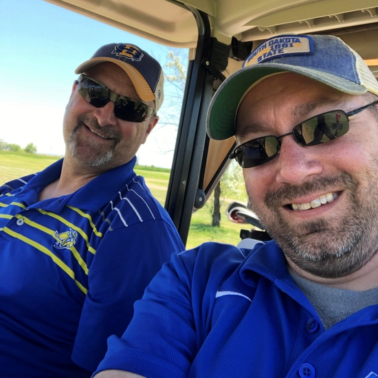 Ned with a friend in a gold cart