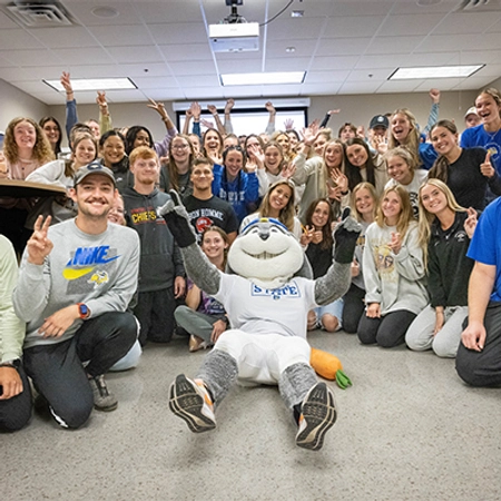 A class at South Dakota State University celebrates with Jack the Jackrabbit during One Day for STATE