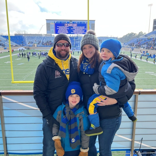 Sara and her husband with two kids at a SDSU football game