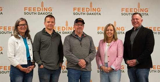 Members of the South Dakota Cattlemen’s Foundation stand together in front of a Feeding South Dakota banner.