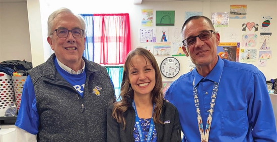 SDSU President Barry Dunn smiles with Carie Green and Norris Elementary School Principal Brian Brown.