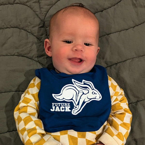 A small child wearing a Jackrabbit bib.