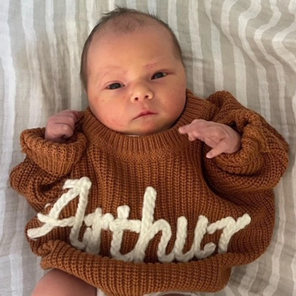 A small child wearing a sweater.
