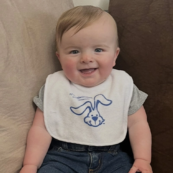 A small child wearing a Jackrabbit bib.