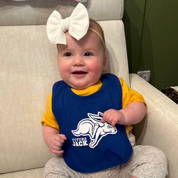 A small child wearing a Jackrabbit bib.