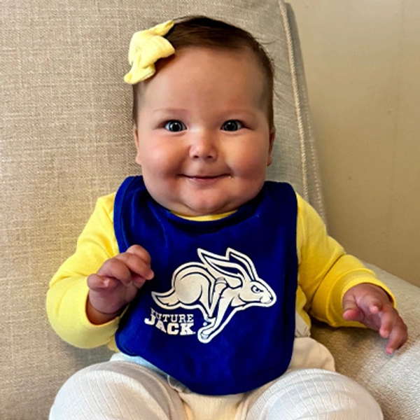 A small child wearing a Jackrabbit bib.