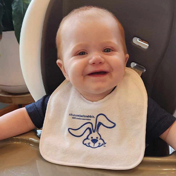 A small child wearing a Jackrabbit bib.