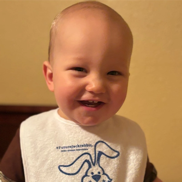 A small child wearing a Jackrabbit bib.