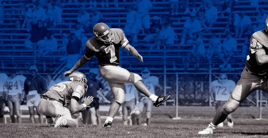 A black and white photo of Adam Vintatieri kicking the football at an SDSU football game.