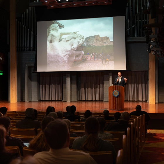 A person presents on stage during the Harding Lectures.