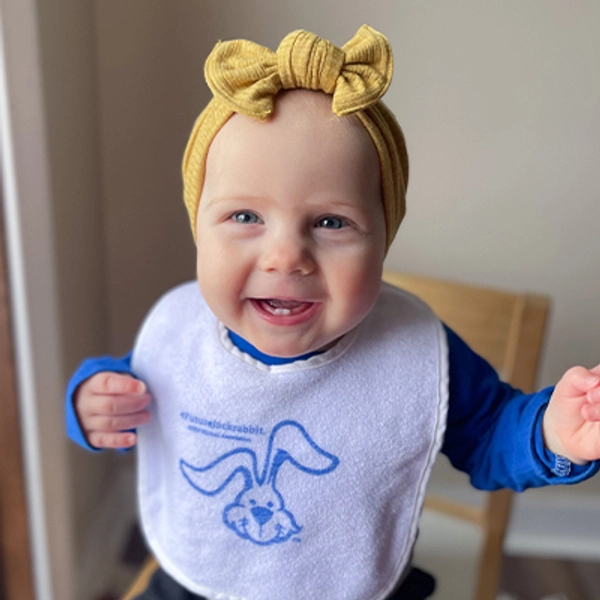A small child wearing a Jackrabbit bib.