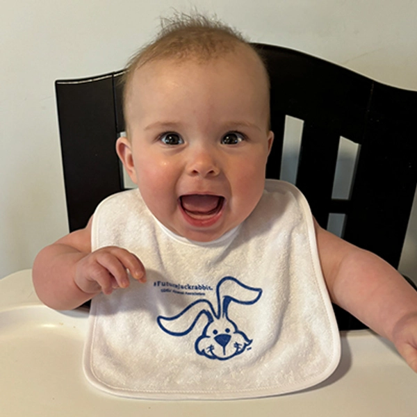 A small child wearing a Jackrabbit bib.