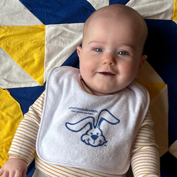 A small child wearing a Jackrabbit bib.