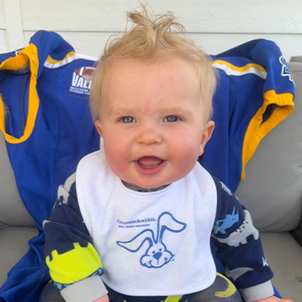 A small child wearing a Jackrabbit bib.