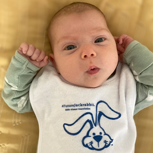 A small child wearing a Jackrabbit bib.