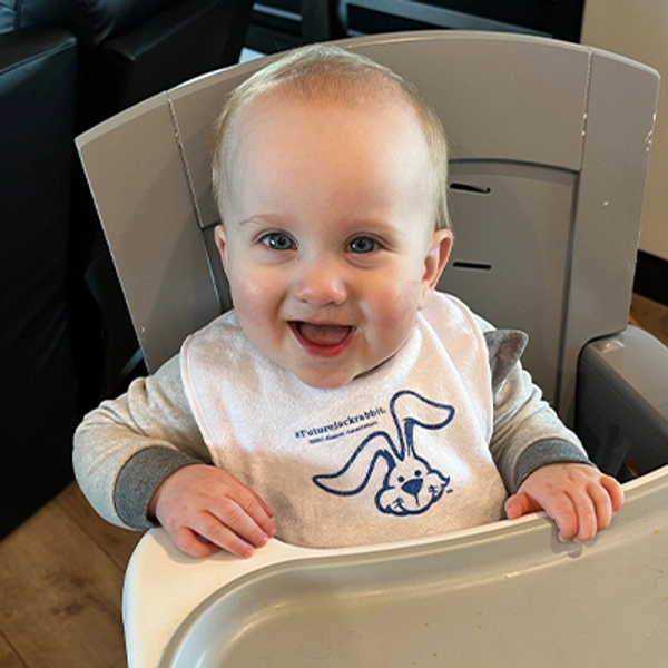 A small child wearing a Jackrabbit bib.