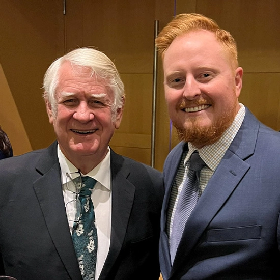 Thomas Hagena stands smiling with an older gentleman.