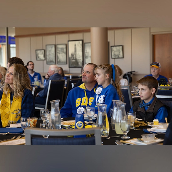 Members of the Moeller family sit at a table listening during the Family of the Year presentation.
