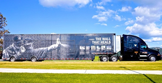 The semi that hauls the Wall that Heals with a blue sky in the background.