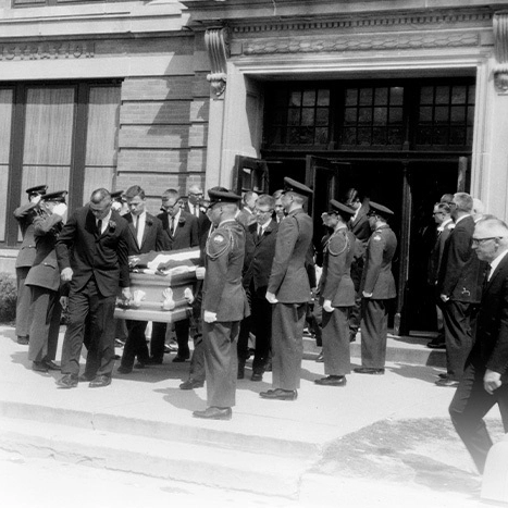 Men dressed in military uniforms carry out a casket at Joe Thorne's memorial service.