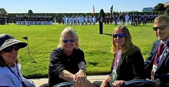 Willibald Bianchi's nieces and nephew smiling and seated in the foreground, wearing sunglasses, attending a military ceremony on the Pentagon's River Parade Field.