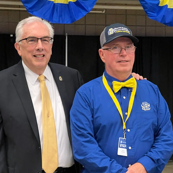 SDSU President Barry Dunn and Tony Filholm smile for a photo.
