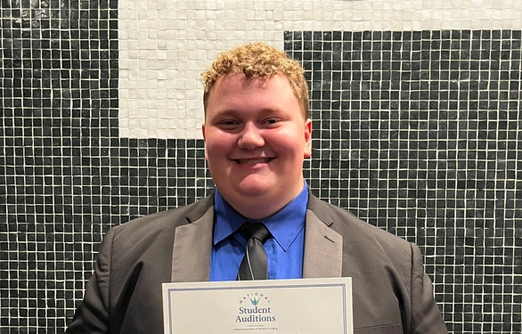 A photo of Steiger Manson holding a certificate.