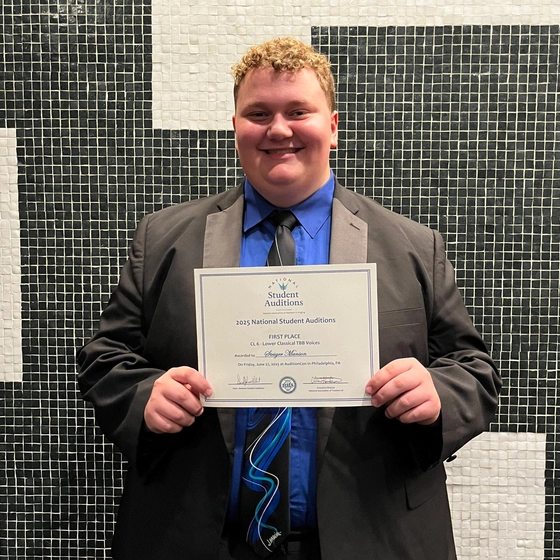 Steiger Manson holding a certificate.