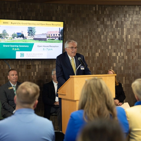 A photo of President Barry Dunn speaking to a crowd of people.