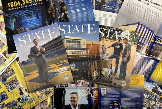 A collage of past STATE Magazines, including covers and individual stories spread out and laid over one another.