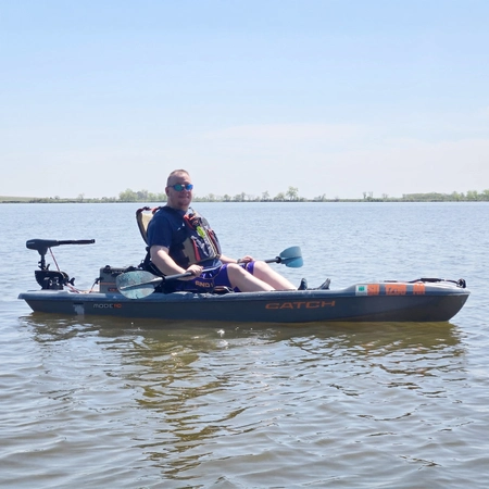 Kevin Lockemy sits in a kayak in the middle of a lake.