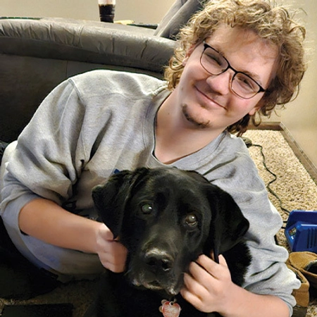 A photo of Luke and his black dog.