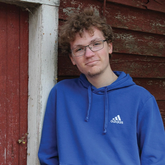A photo of Luke in a blue Adidas sweatshirt.
