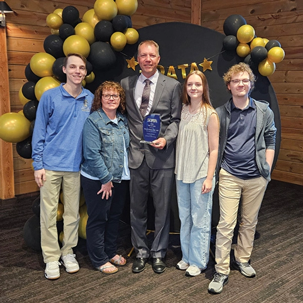 A photo of Luke with his parents and his brother and sister.