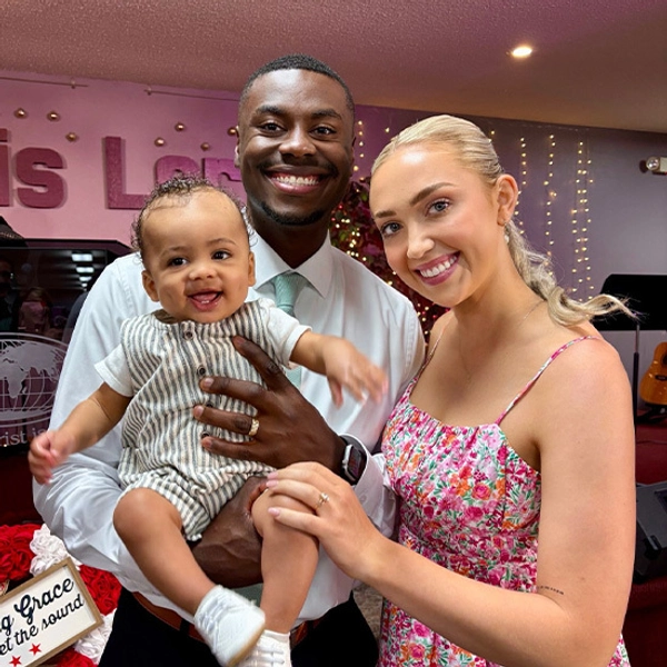 Pierre, with his wife and son, smiling for a photo.