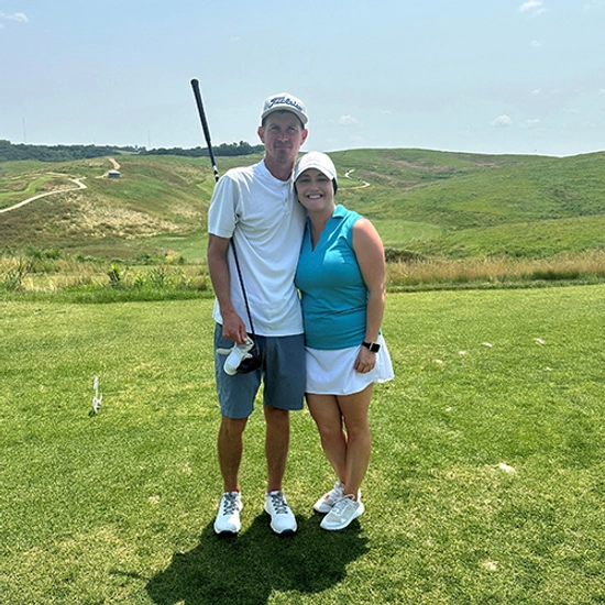 Kayla Schinkel and a gentleman stand together on a golf course