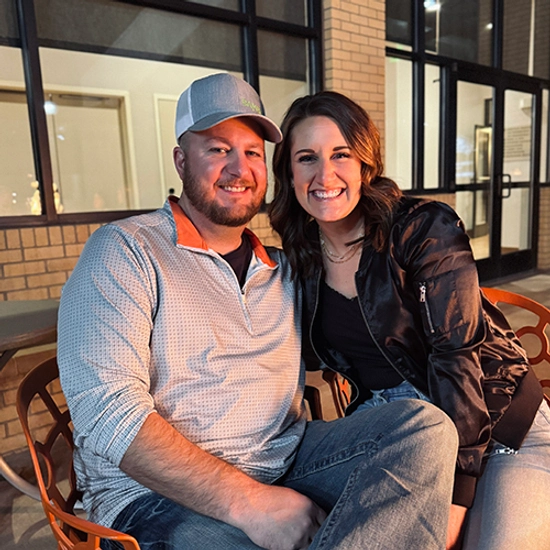 Jenn McCloud smiles while sitting with her husband.