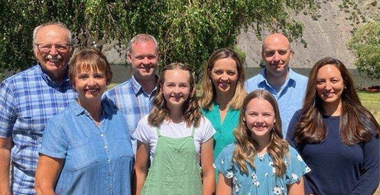 The Dettman family standing outdoors and smiling for the camera.