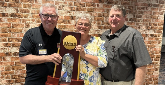 Cindy and Randy Frederick with former SDSU head football coach John Stiegelmeyer holding the National Championship trophy.