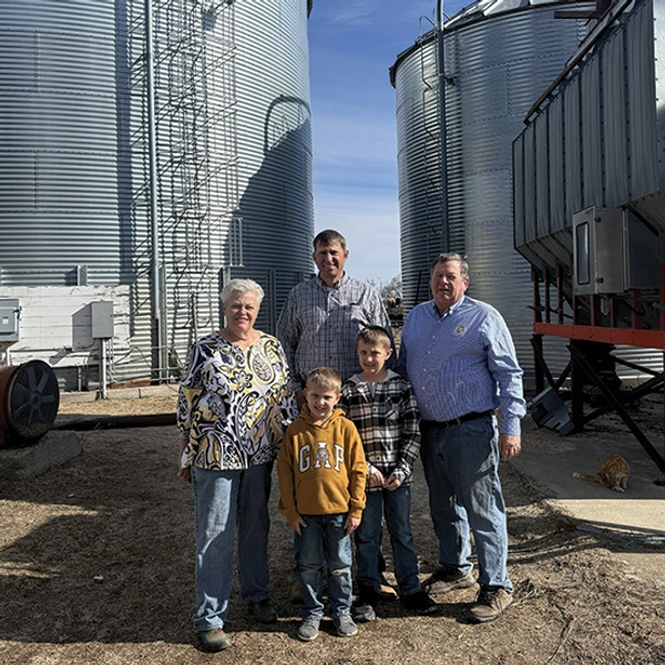 Cindy and Randy Frederick, with their son and two grandsons, standing in front of grain bins on the farm.