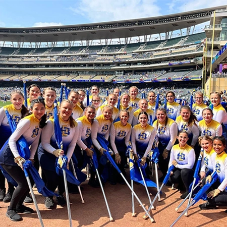 The flag team with the Pride of the Dakotas smiles together at Target Field.