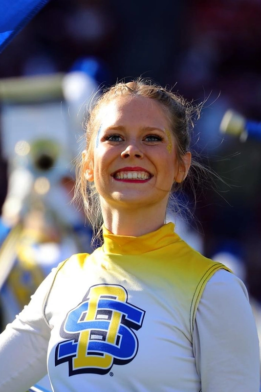 Hannah Hank smiles proudly while performing her flag routine with the Pride of the Dakotas.