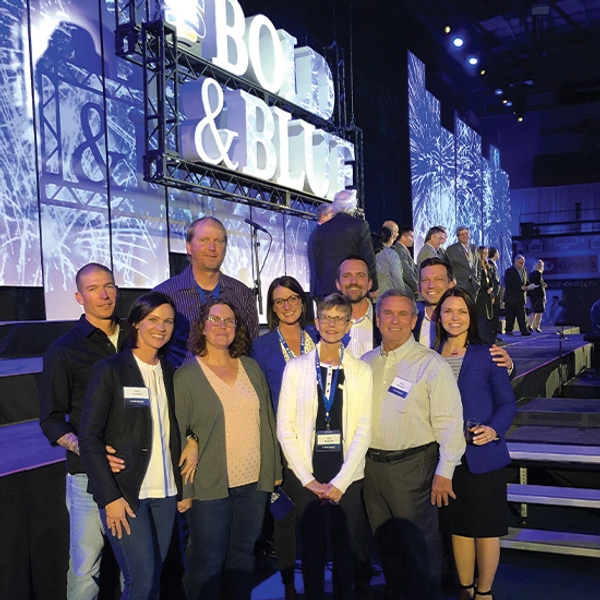 The Ramsdell family standing in front of an SDSU Bold and Blue sign.