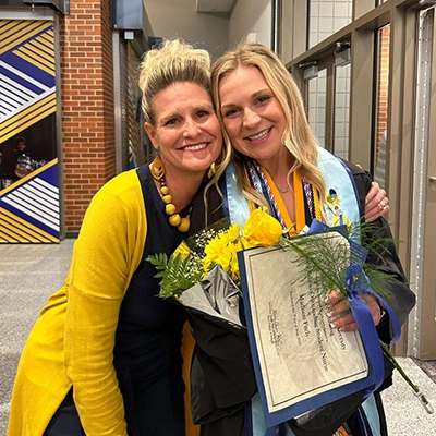 A photo of Erica DeBoer and Maddie Fitch smiling for the camera after SDSU graduation.